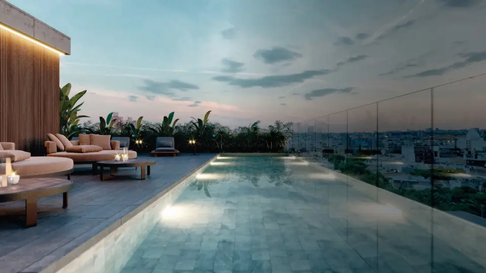Piscina del rooftop con reposeras y vista a la ciudad